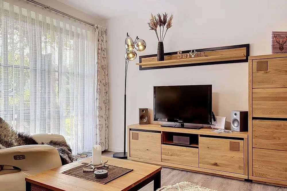 Wohnbereich mit Fernseher und Holzmöbeln